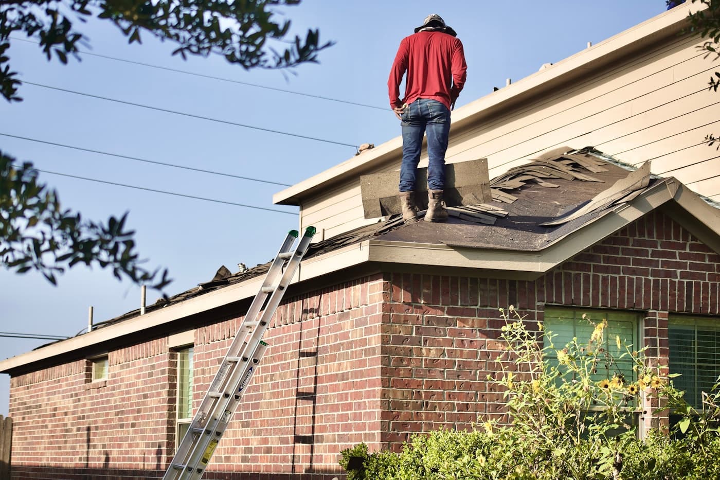 Ironclad Roofing crew member tearing off old shingles on a residential roof in Georgetown, TX